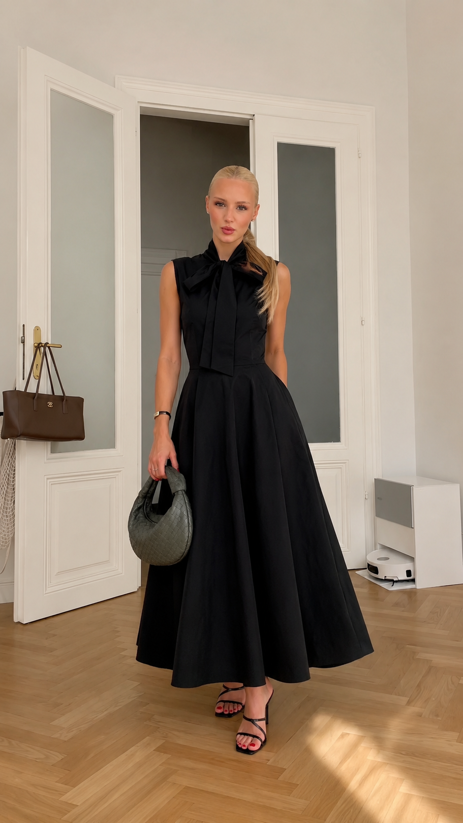 Front view of black sleeveless bow neck midi dress with full skirt