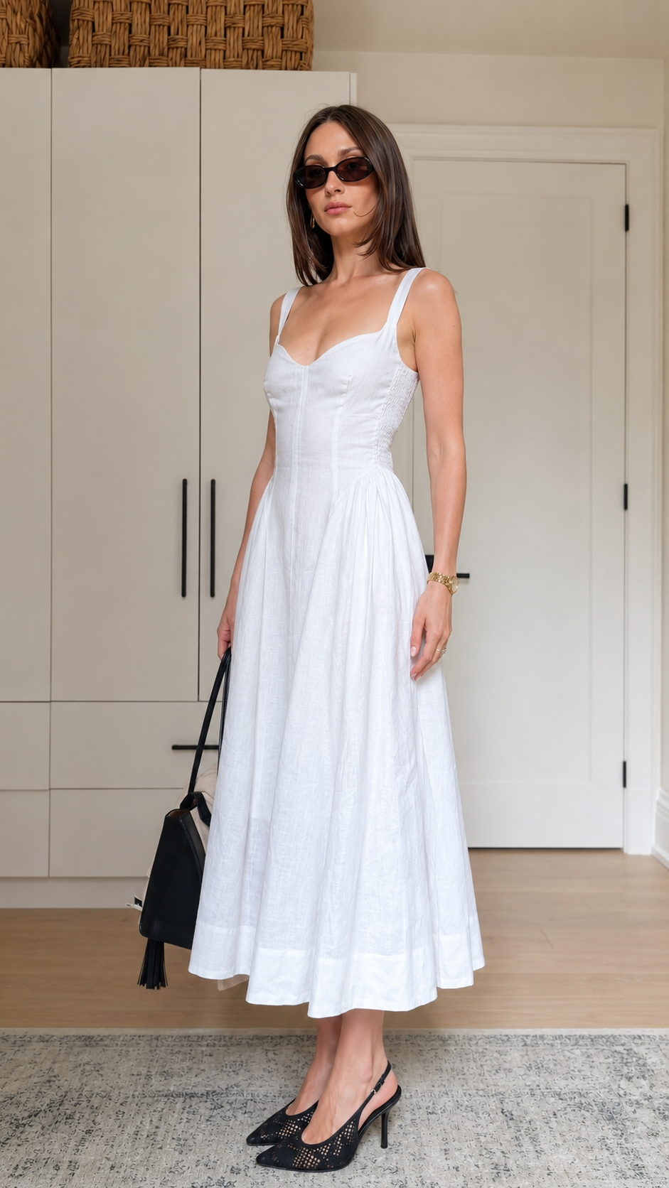Side front view of a white sleeveless sweetheart neck midi dress with fitted waist and flowing skirt