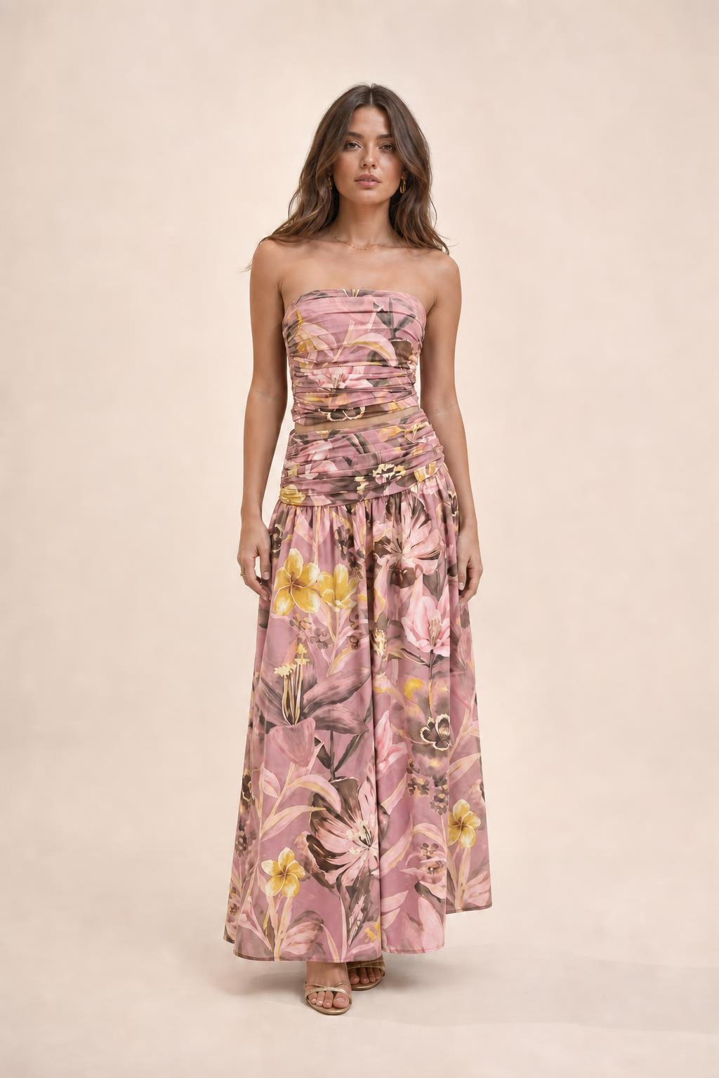 Model wearing pink floral strapless crop top and maxi skirt set