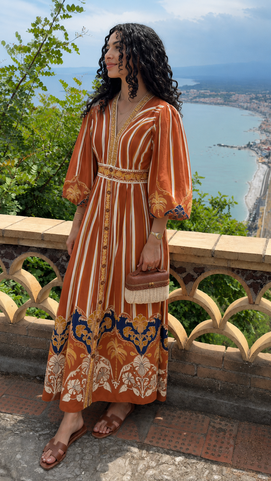 Front view of rust bohemian print V-neck maxi dress with ornate border hem