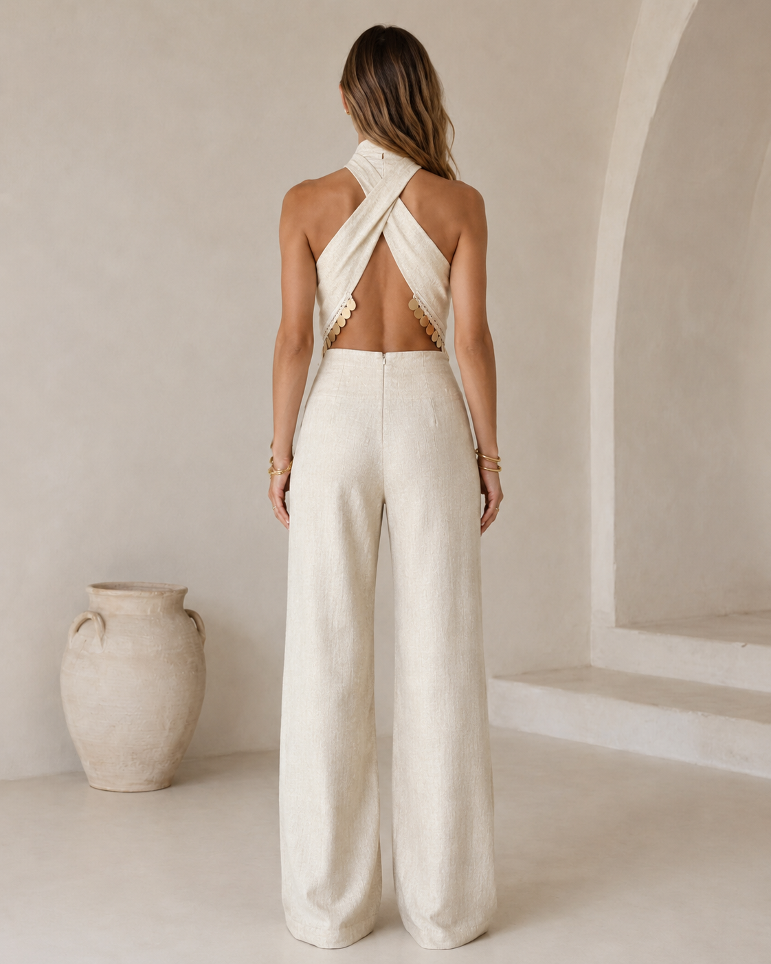 Back view of ivory open-back crossover halter jumpsuit