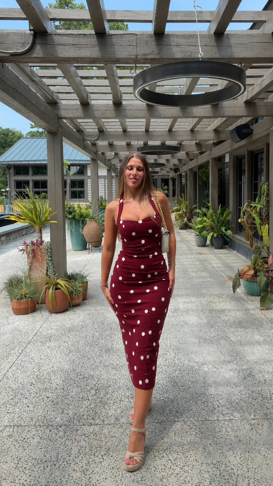 Front view of burgundy polka dot fitted midi dress