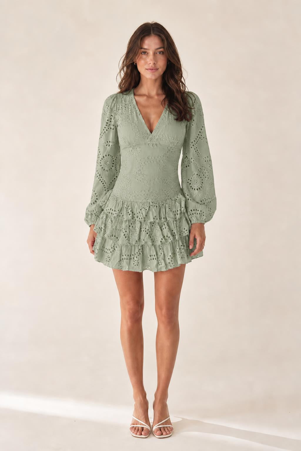 Front view of model wearing sage green eyelet mini dress