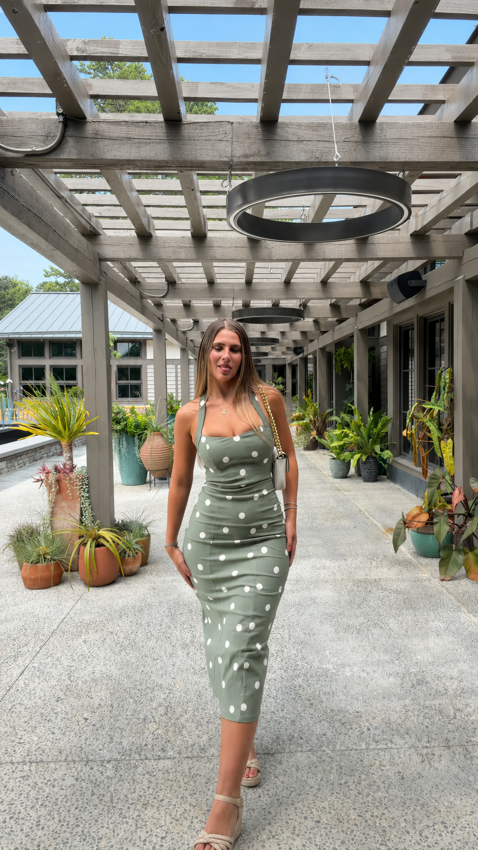 Front view of sage green polka dot sleeveless midi dress