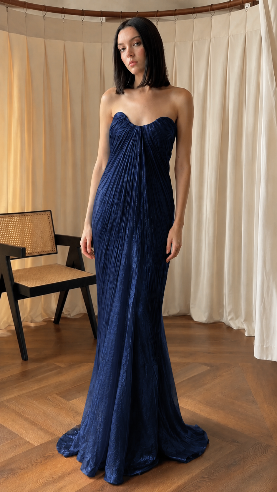 Front view of navy strapless pleated mermaid formal dress