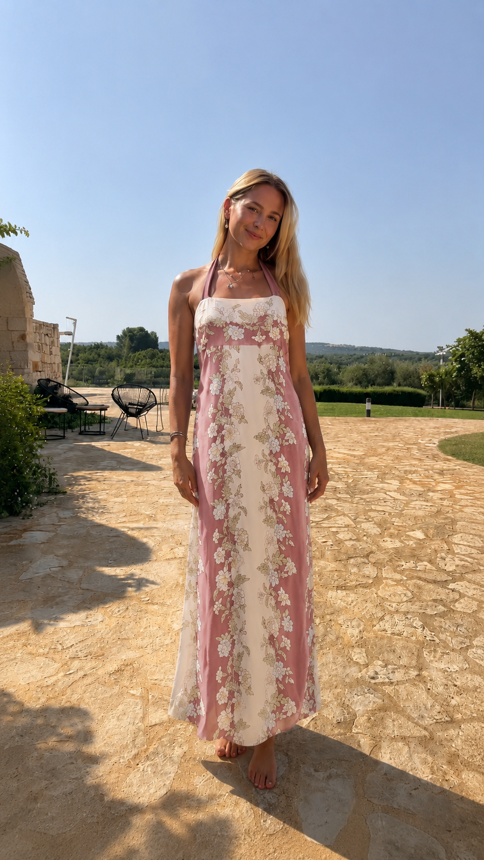 Model wearing blush pink and cream floral halter neck maxi dress front view