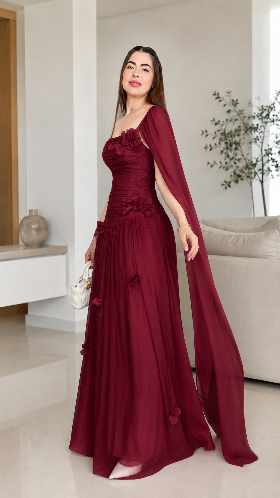 Burgundy one-shoulder evening gown with ruched bodice and cape sleeve