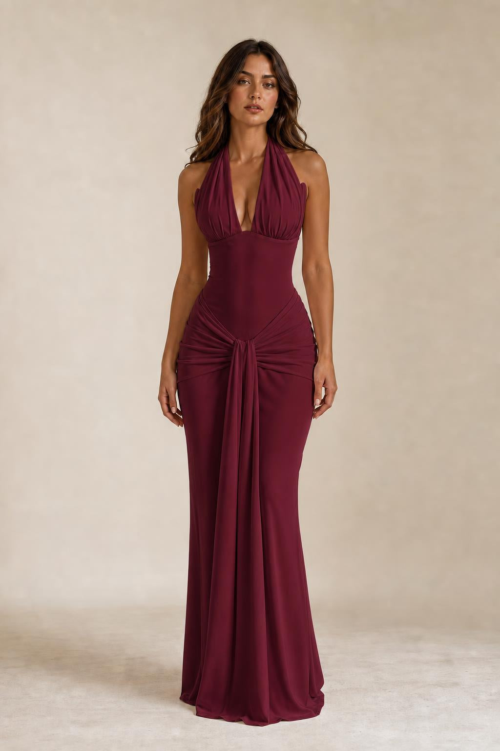 Front view of woman wearing burgundy draped halter neck maxi dress