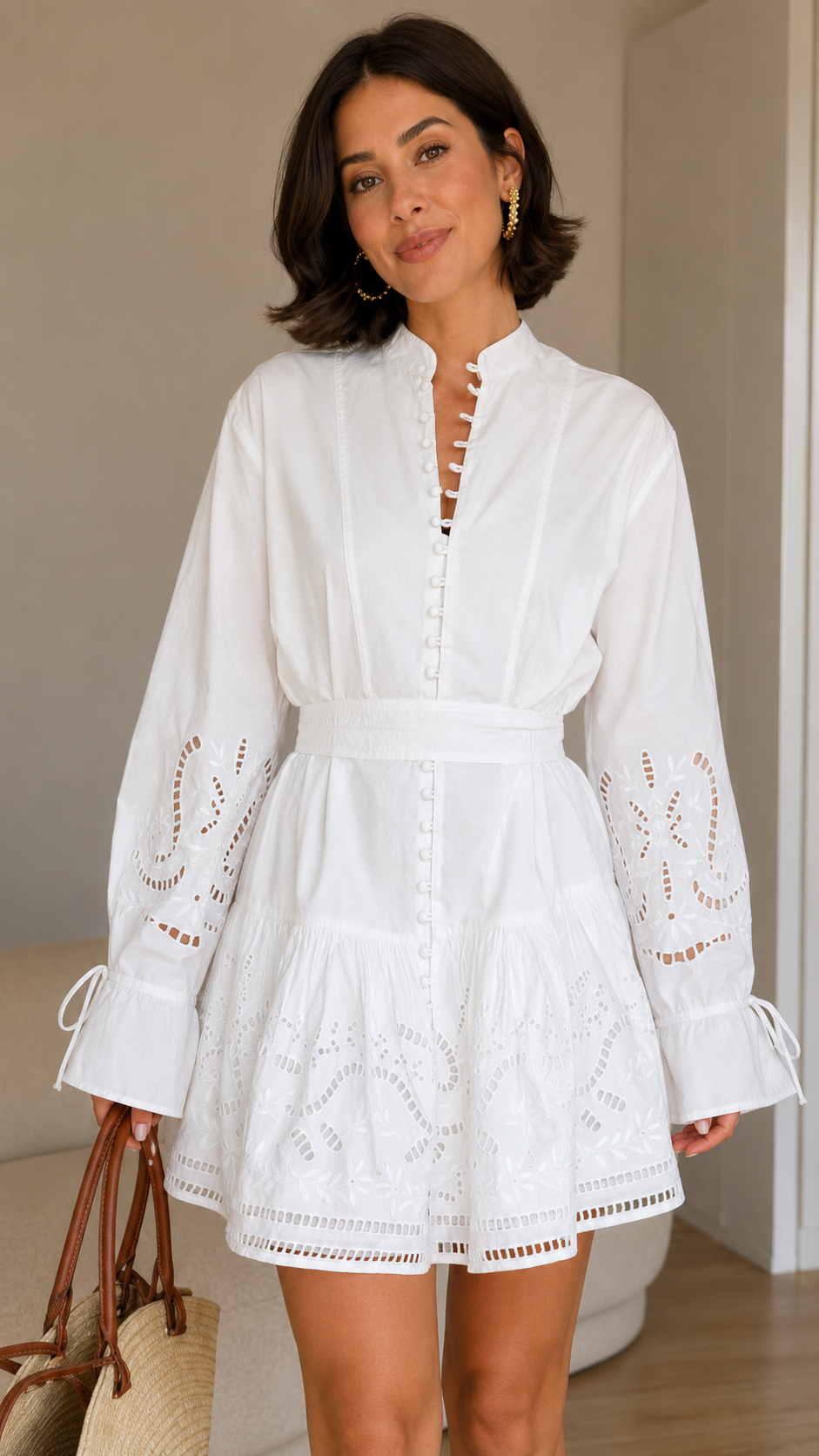Close-up of white embroidered mini dress with split neckline and waist tie