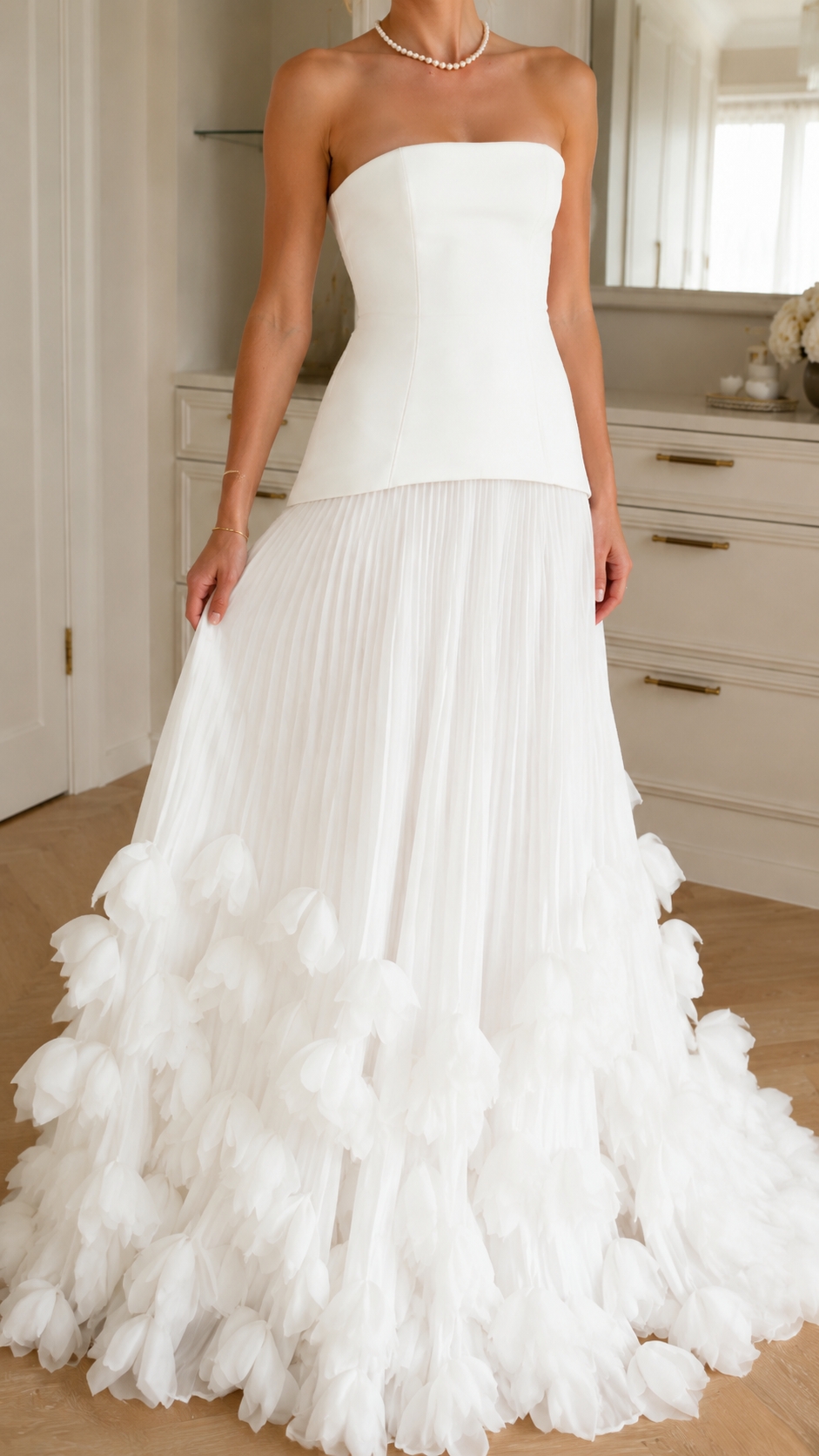 Close front view of ivory strapless dress showing fitted bodice and pleated skirt detail
