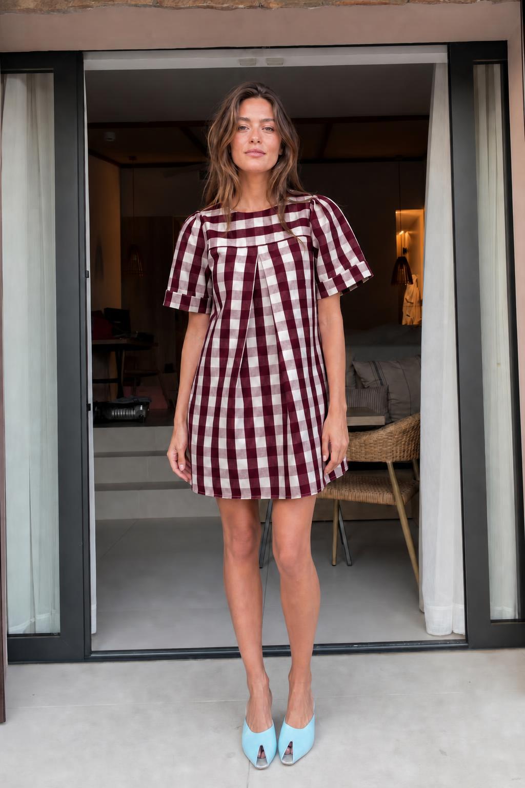 Front view of woman wearing burgundy gingham check mini dress