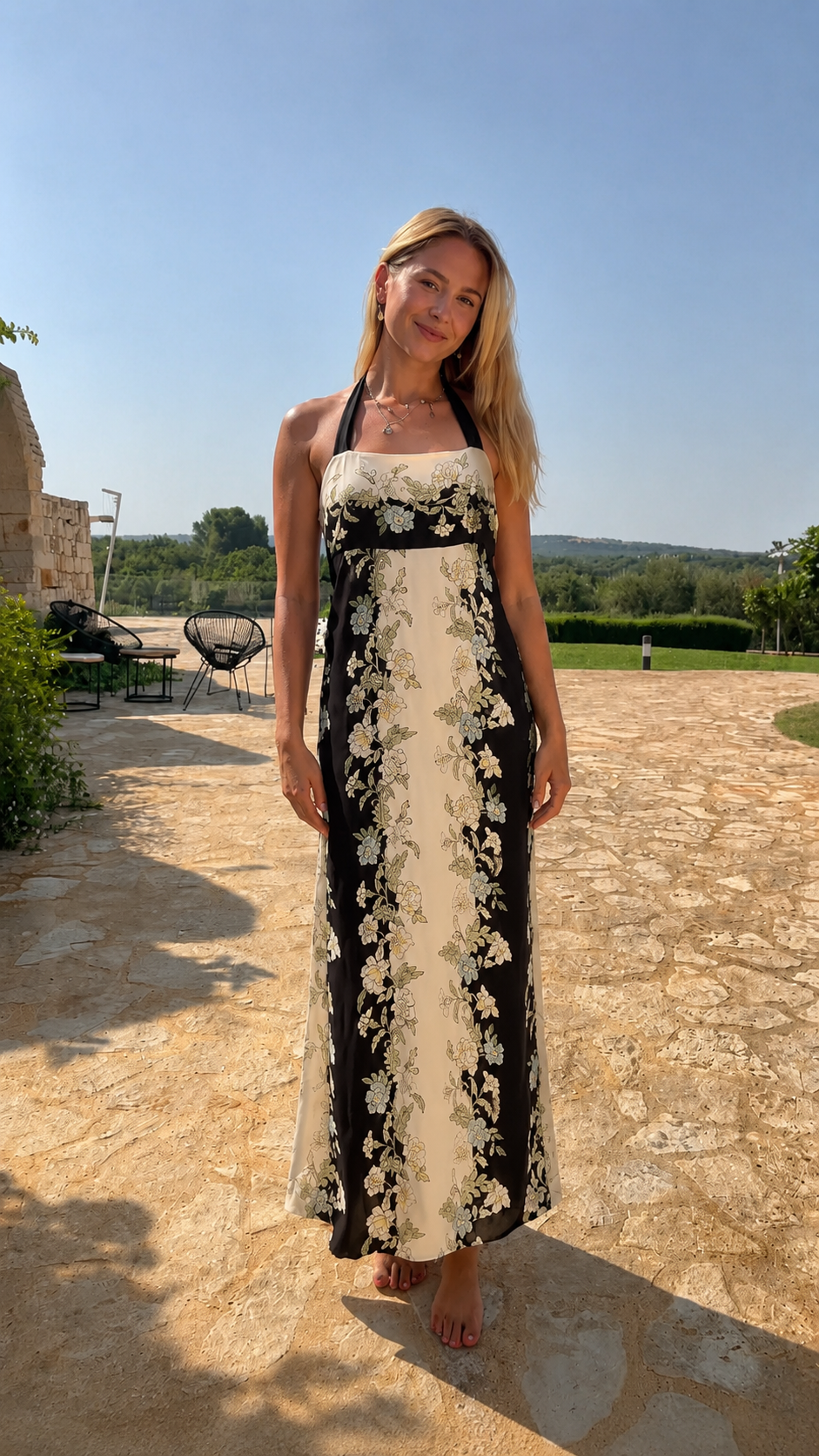 Model wearing black and cream floral halter neck maxi dress front view