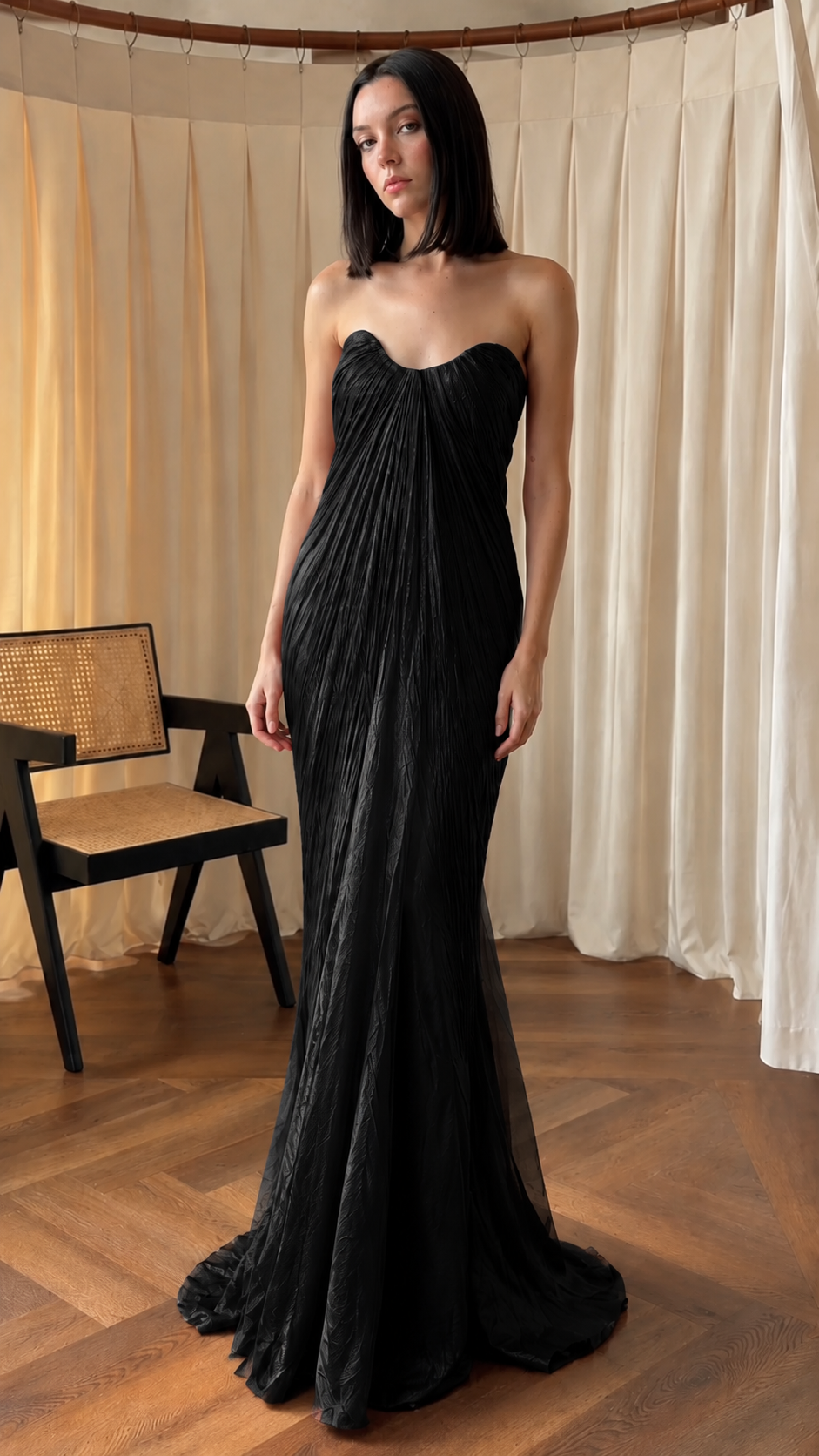 Front view of black strapless pleated mermaid gown