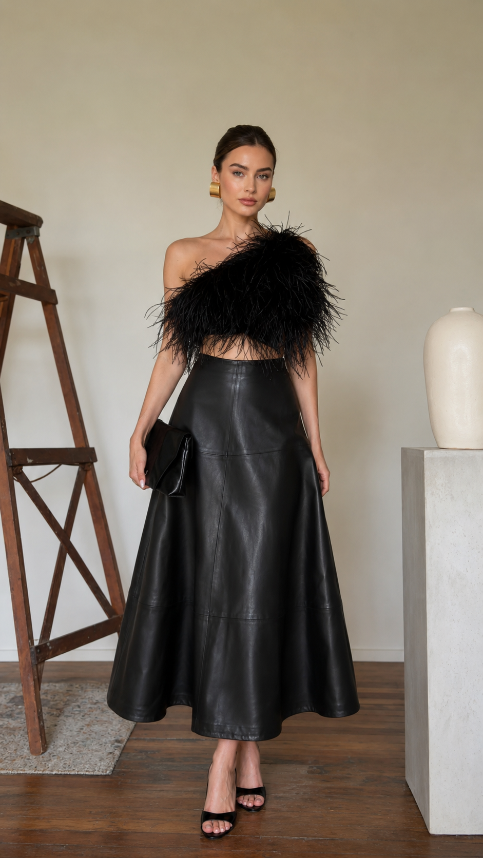 Front view of the black high-waisted faux leather A-line midi skirt with a smooth leather-look finish