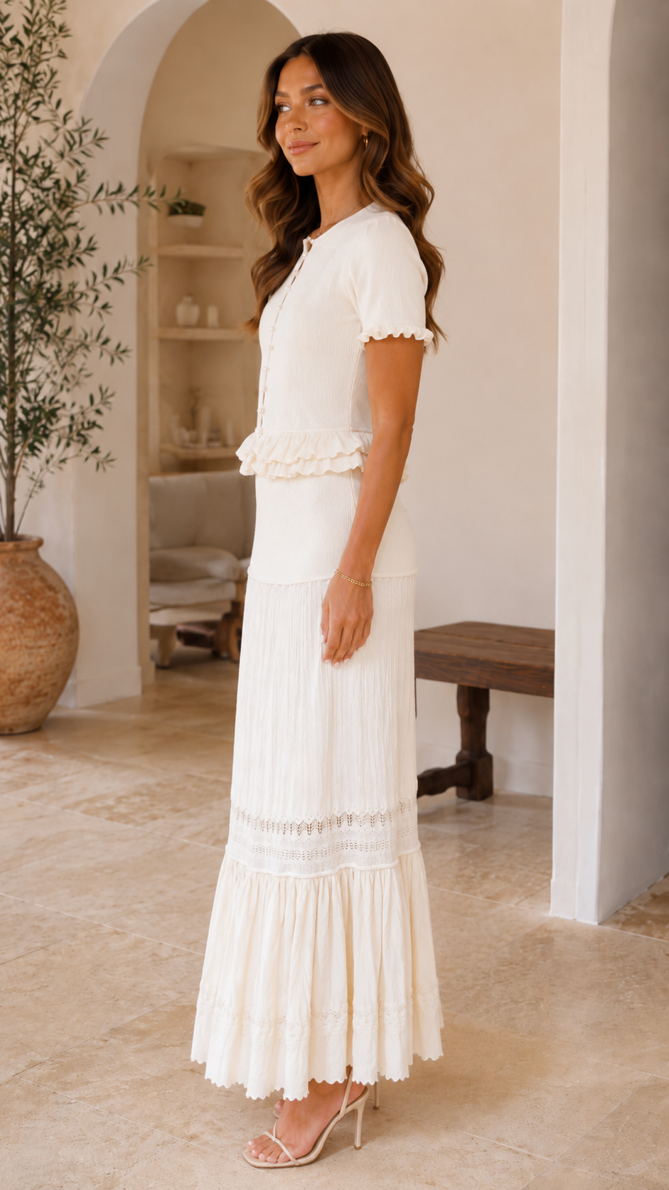 Side view of cream maxi dress with fitted bodice and full-length skirt