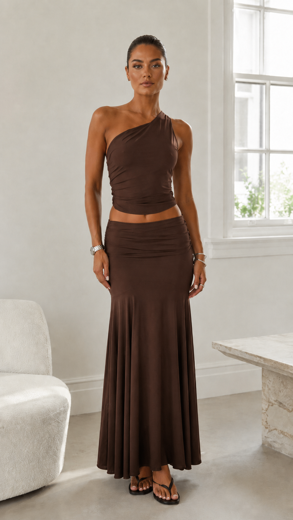 Front view of espresso brown one-shoulder ruched crop top and maxi skirt set